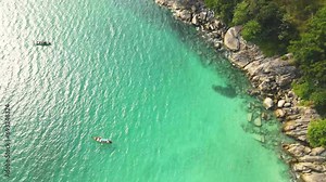 Freedom beach, Patong Phuket, Thailand - Tropical island with white paradise sand beach and turquoise clear water and granite stones. Drone high angle video.