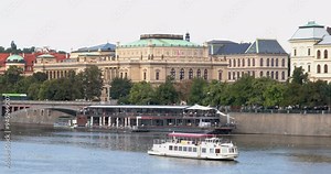 Historic riverfront in Prague featuring a boat cruise and beautiful architecture along the Vltava River