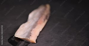 salted herring fillet on the table, delicious salted herring marinated in salt and spices
