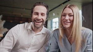 Smiling family couples talking on video waving their hands from cafe. Chatting online by web camera. Sitting in cafe. Slow motion