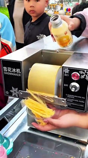 Snowmaker machine extruding shaved ice strands into cup