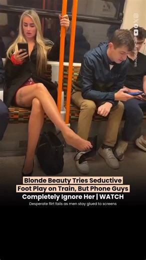 A woman identified as Cassie was seen inside a metro train, taking off one of her high heels and stretching her bare foot toward a man seated opposite her, seemingly trying to get his attention. She moved her foot repeatedly, dropped and picked up her shoe, and acted flirtatiously but both men remained focused on their phones, completely ignoring her throughout the clip.