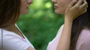 Affectionate kiss of two attractive lesbians, first love, secret meeting closeup