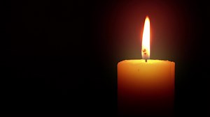 single candle in dark ,black background.Loop video clip.