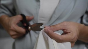 Women hand with scissors to cut the yarn