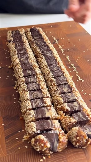 Burçin Arda|Pastry Chef on Instagram: "Hurma Bar Malzemeler 20 hurma 100 g ceviz(1 su bardağı) Susam 120 g bitter çikolata Hazırlanışı Hurma ve cevizi robotunda çek un ufak olacak görüntüsü ardından tezgaha alıp elinle toparla 2 eşit parçaya böl fitille susama bula ardından orta kısmına videodaki gibi şekil ver sonra olarak benmaride eritilmiş çikolatanı ekle üzerine tahinle desen ver çikosu donduktan sonra 2 parmak büyüklüğünde parçalara ayır afiyet olsun 😋 görüşürüz hadi gittim ben &#x