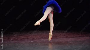 A ballerina dances en pointe on stage during a performance.
