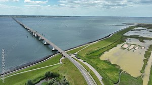 Zeelandbridge infinity bridge in the distance aerial drone view. part of Delta works. Dutch infrastructure holland Zeeland. Transporation delivery logisitics road. Overhead view. Holland.