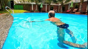 Bearded Old Man Swims along Oval City Swimming Pool