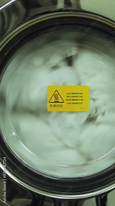 Washing machine turning close-up. Scene. Industrial washer machine working. Close-up of laundry clothes in industry washing machine