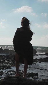 Woman Ocean Coastline Standing Looking Seascape Woman Beach Ocean Waves - A woman sits on a rock on a beach as ocean waves crash against the shore.