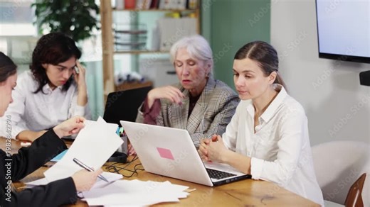 Tired women staff sitting at computer at work in crowded office. Grueling work, long hours. Travel agency, business regional representative office of international company, engineering company