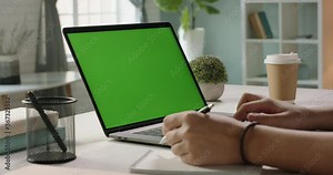 Close up shot of hands of student working with chroma key green screen laptop, using trackpad and pen with notebook in living room - technology concept 4k video template Stock Video