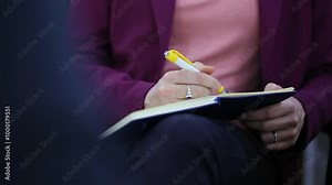 Person holding a pen writing in a notebook. focusing on the act of taking notes or jotting down thoughts, conveying concentration and productivity
