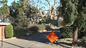 A house burned by wildfire just beyond a Utility Work Ahead sign