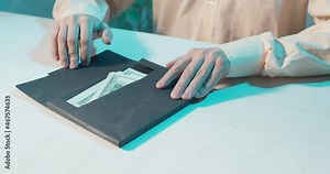 hands on the table pass the envelope. a person checks the availability of money and hides a bribe or earnings under the table. close-up