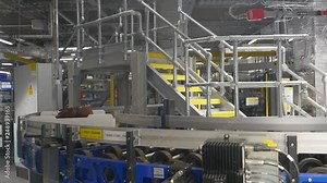 Luggage being sorted and delivered by a large machine at a major international airport. Huge conveyor belt system automatically routes bags to the proper flight. Airport baggage handling system.