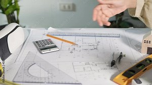 Architect team success and handshaking after meeting consult and work for architectural construction project with partner editing on blueprint paper plans, Architect and engineer shaking hands