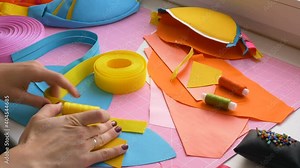 Creative woman seamstress designer selects the right colors of fabrics and straps for her product at home, hands close-up. Remote freelance work from home. A talented seamstress tries on yellow and