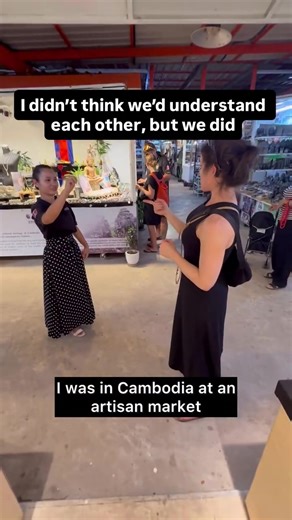 I was walking through an artisan market in Cambodia when I noticed two girls signing to each other. I went over just to say hello, not expecting we’d be able to understand one another. Sign language isn’t universal. It varies across countries and cultures. But to my surprise, they knew some ASL. It turned into a moment I’ll never forget, a reminder that even when language is different, connection finds a way. Accessibility: Rebecca is wearing a sleeveless black dress and smiling mid-sign while i