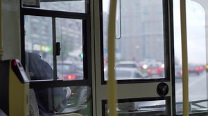 View to bus cabin with female driver and road traffic