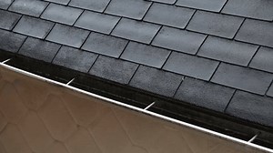 a gutter on the roof of a house during a downpour