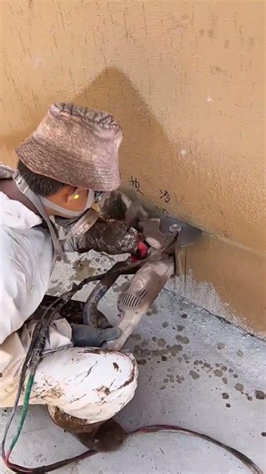 Cutting a concrete wall using an electric saw and water to prepare a groove for installing pipes now