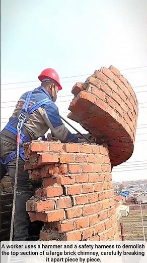 The process of demolishing a large brick chimney