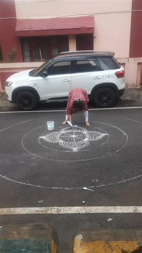 Prathima Dattatreya on Instagram: "Somehow could do the rangoli for Visarjane in our Colony. Today Varuna Bhagavan also gave us company in drawing the rangoli.I took the challenge and completed though it was raining. He too took sympathy on me and didn't erase my rangoli. Thank God. You can see in the video how I did. I wanted to do the design using calligraphy tool but couldn't as it was raining i couldn't keep the lid open. So finished with bottle.Advantage of using the bottle. 💃🏻💃🏻😂😂😂�