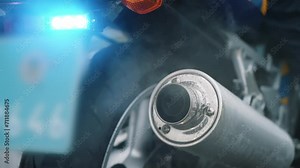 Close-up of the exhaust pipe of a police motorcycle blowing smoke into the air. Slow motion. Breakdown on a motorcycle