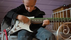 Little boy playing electric guitar and singing at home. 4k video footage UHD 3840x2160
