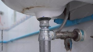 Plumber Repairing broken water pipes in bathroom, Technician Asian elderly Worker builder, repairman with Tools Repair Leaking Pipe. Talented foreman elderly people adjustable wrench holds plumbing