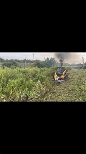 Brush Hog attachment going through tall grass and debris