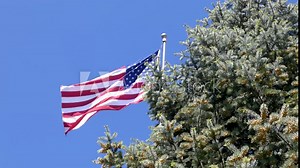 American flag flying proudly against a brilliant blue sky.