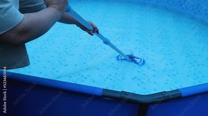 Long-handled vacuum cleaner girl's hands to clean the bottom of the pool. Cleaning and filling the pool with water at the beginning of the summer season Stock Video