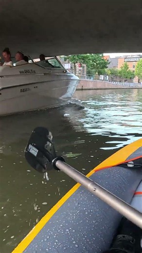 Boat passing kayak on city canal