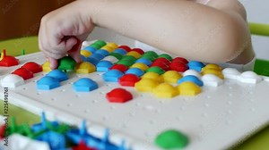 child plays a game of developing motility, collect a designer multicolor mosaic for children, development of thinking, learn colors, white background