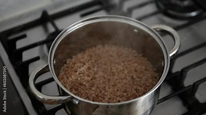 Brew buckwheat porridge in a saucepan. Cook buckwheat porridge. Steaming buckwheat porridge