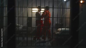 Cinematic shot of male prisoners fighting in prison cell. Criminals in orange uniforms talk, hit each other in jail or detention center. Fighting scene playback for epic action movie. Film production.