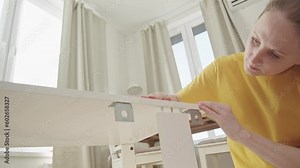 Woman self assembly of furniture at new home sitting on floor Stock Video