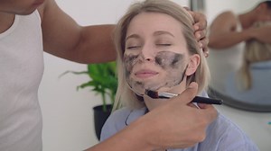 Free stock video - Portrait of a female having a dark facial mask applied
