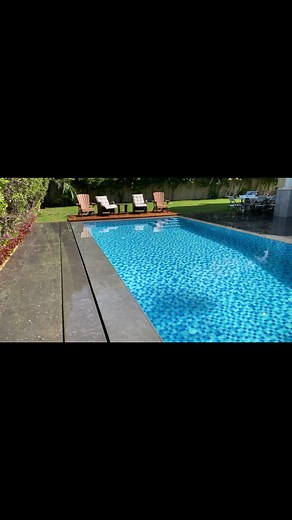 Diseño de piscina desbordante con deck de madera