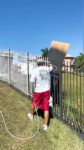 Spraying a metal fence charcoal with Sherwin Williams DTM paint #paint #painting #sherwinwilliams #luxury #new #spray #capecoral