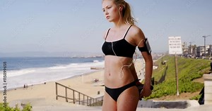 Beautiful young woman stretching on a sunny beach