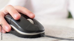 The childs hand moves the computer mouse to the sides while playing a video game or working on a laptop. The boy presses buttons with his fingers, does homework or online education concept. Close-up. Stock Video
