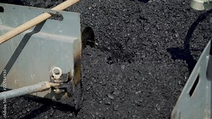 professional equipment with a mixer is blending a mix of rubble, tar, sand and bitumen for stowage asphalt on the highway. Manufacturing technology of asphalt concrete sweep for road works
