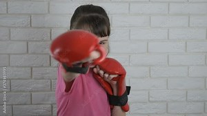 Boxer girl. A teenage girl in boxing gloves stands in a rack and hits forward.
