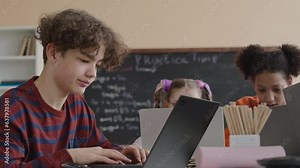 Waist up of frustrated Biracial preteen schoolboy looking blankly on laptop screen while trying to understand program coding during IT lesson
