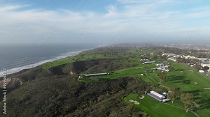 Aerial view of Torrey Pines Golf course on a partly cloudy day in La Jolla San Diego California with views of the Pacific Ocean and Blacks Beach along the cliffs and hills