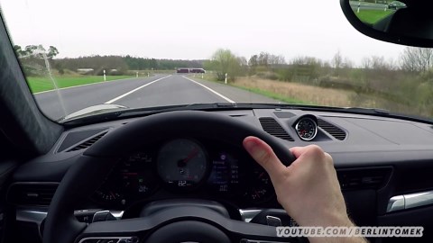 Onboard view driving Porsche 911 at full speed on busy traffic road